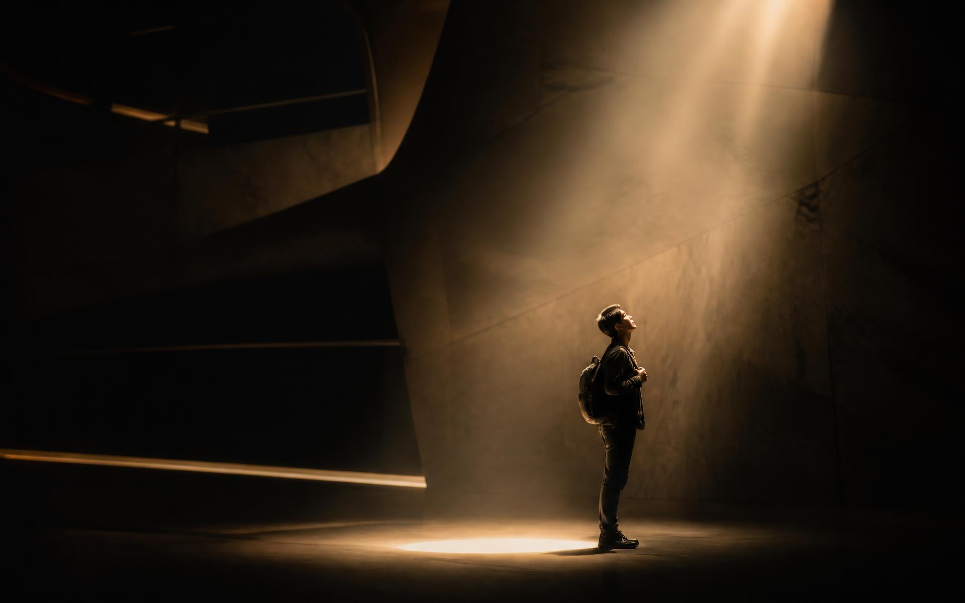 A student standing in a shaft of light
